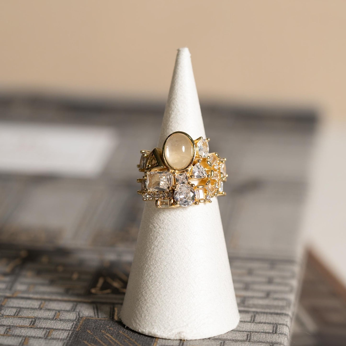 Anillo Opulencia Dorada con Piedras Mixtas y Gema Central